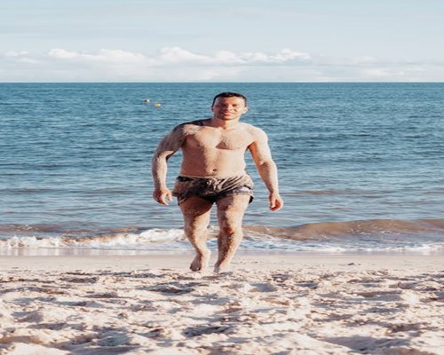 Man walking on the beach at sunset